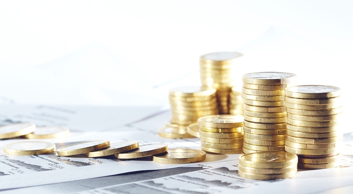 Seks stakke af mønter på bord oven på papirer