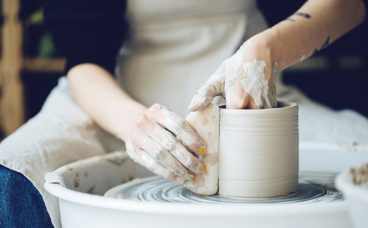 Person sidder og laver keramik