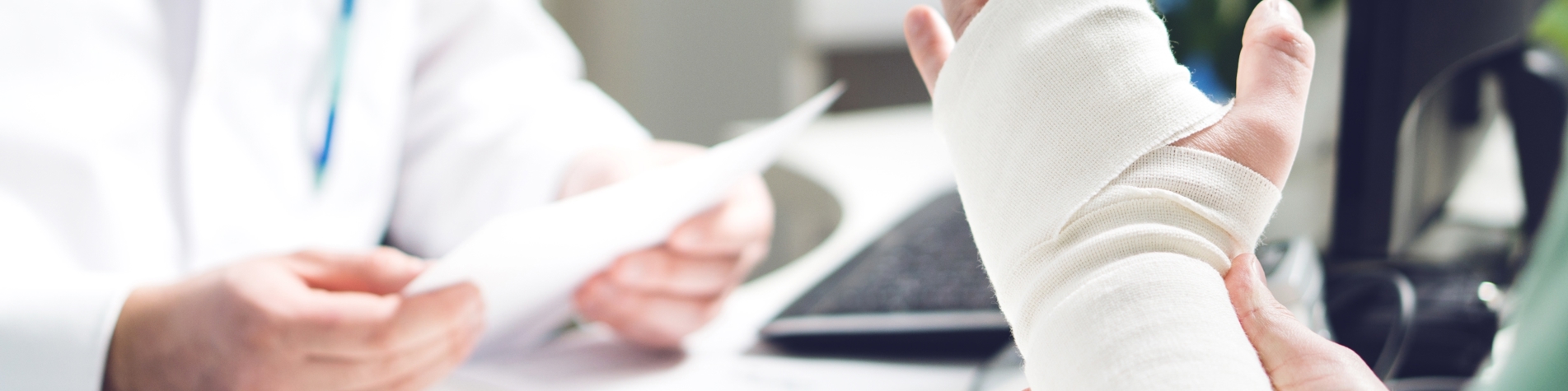 Person med brækket hånd sidder ved lægen - erstatningsansvar