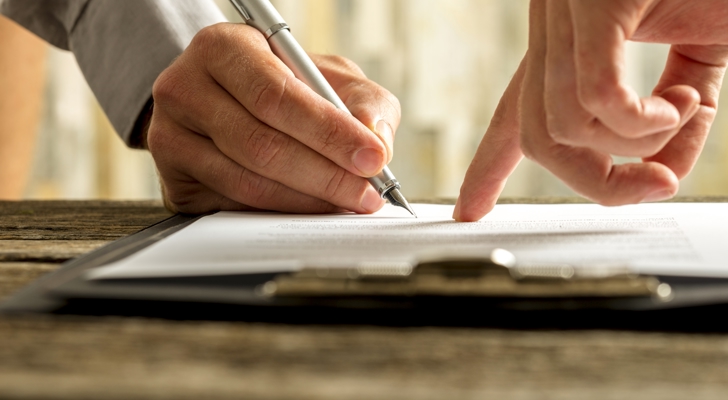 Hænder der skriver under på dokument