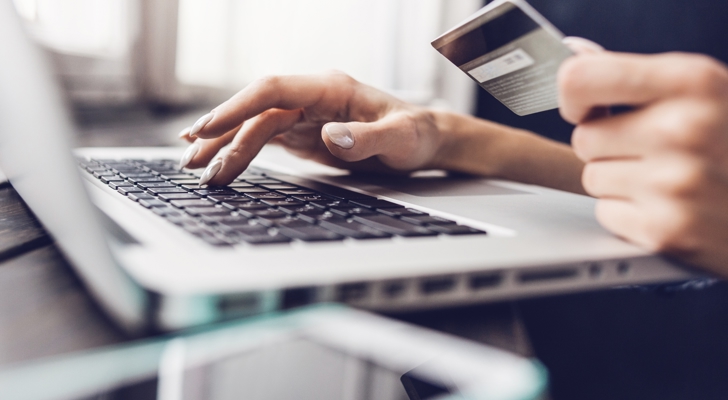 Person sidder ved computer og betaler online med dankort