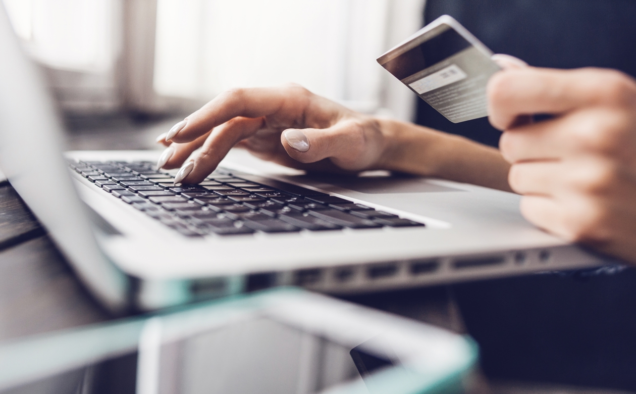 Person sidder ved computer og betaler online med dankort