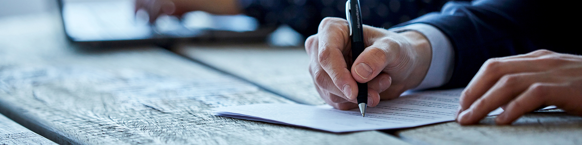 Person underskriver kontrakt med kuglepen