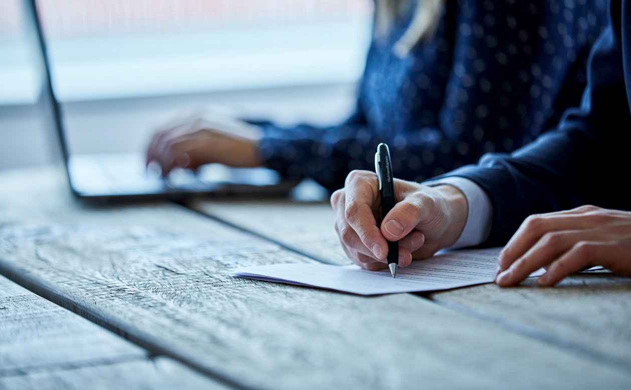 Person underskriver kontrakt med kuglepen