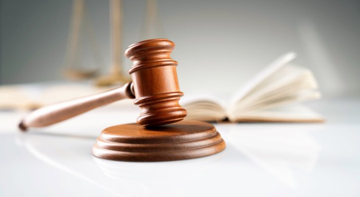 Dommerafgørelse ved dommerhammer med loven i baggrunden 