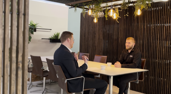 To personer hos Raw solution sidder ved mødebord