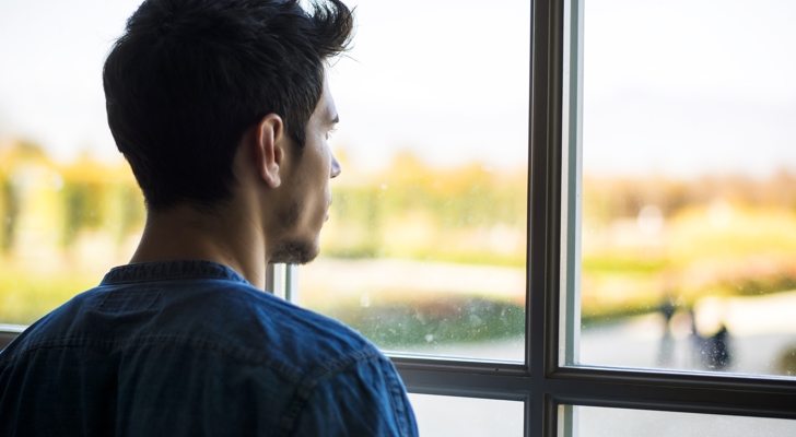 Mand kigger ud af vindue