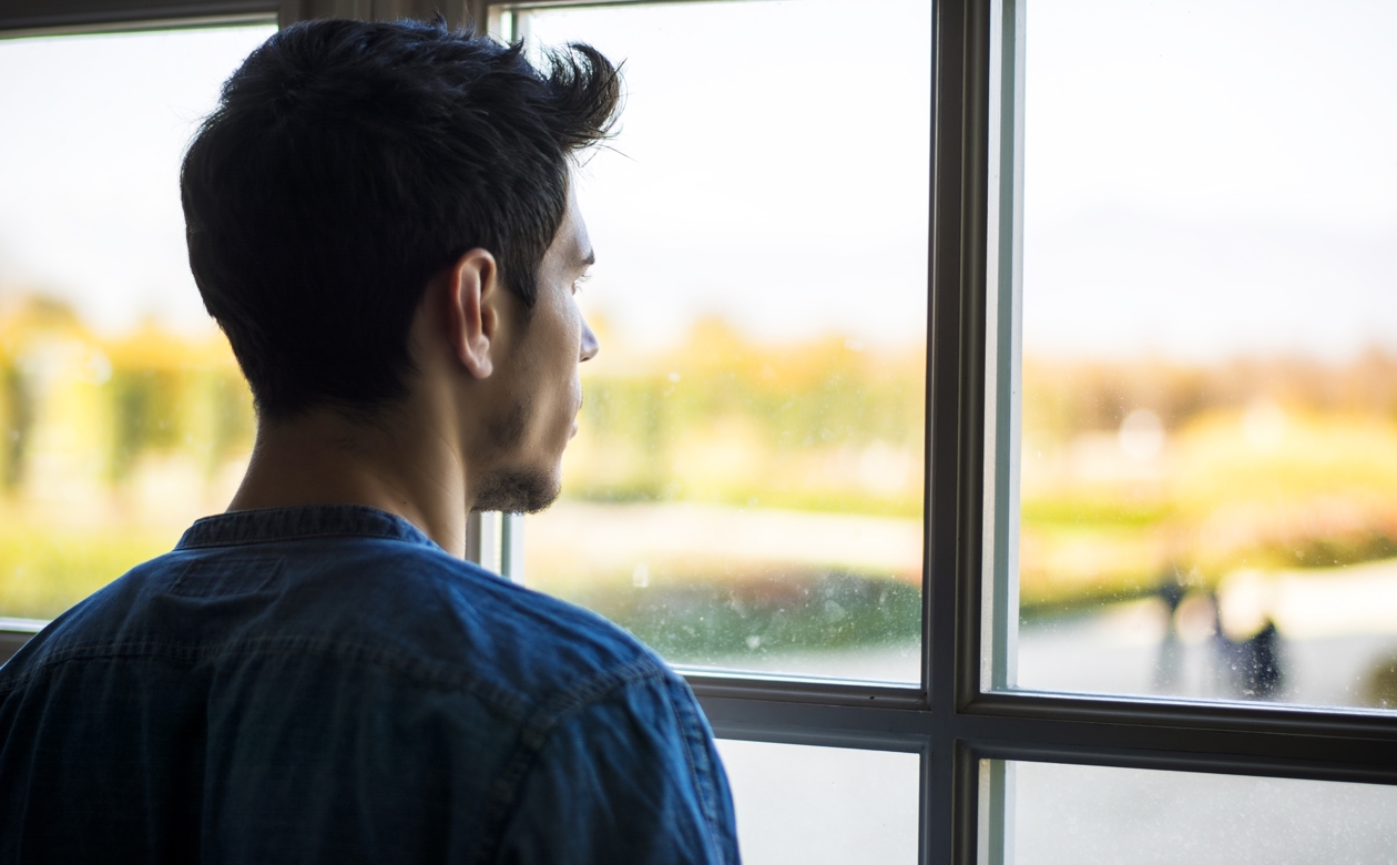 Mand kigger ud af vindue