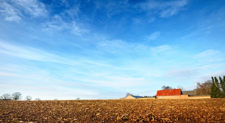 Gård på en mark med blå himmel - planloven