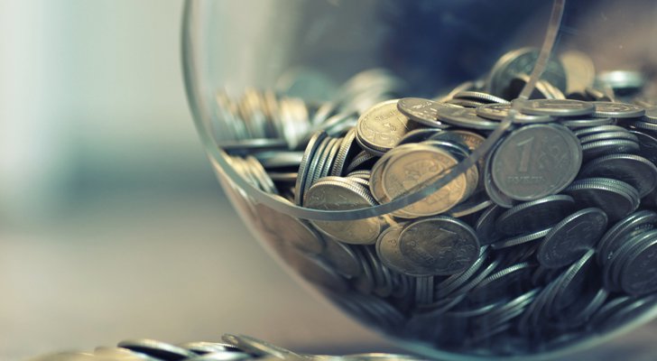 Mønter i glasbowle som er væltet