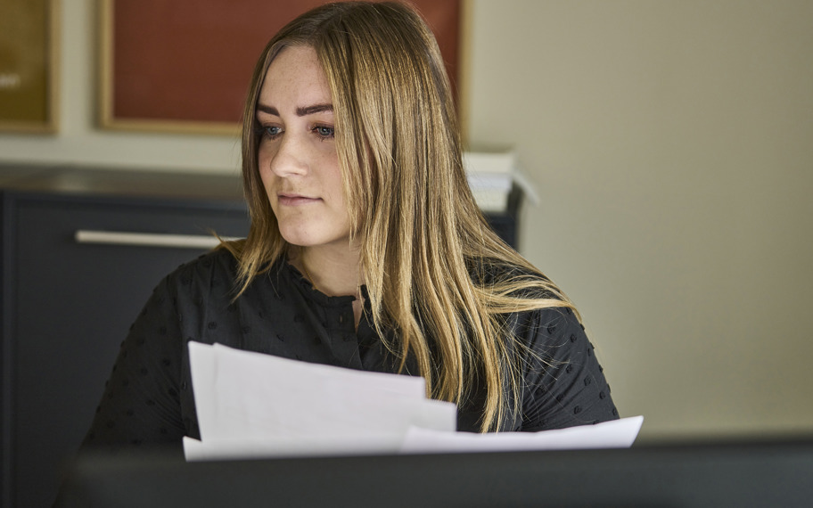 Erna Sverrisdóttir sidder ved computer med papirer