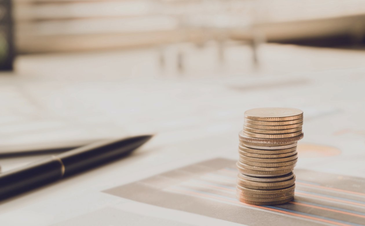 Stablet mønter og kuglepen ovenpå en aftale