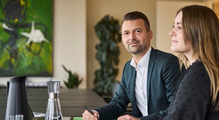 Lars Østerstrand og kvinde sidder ved bord 