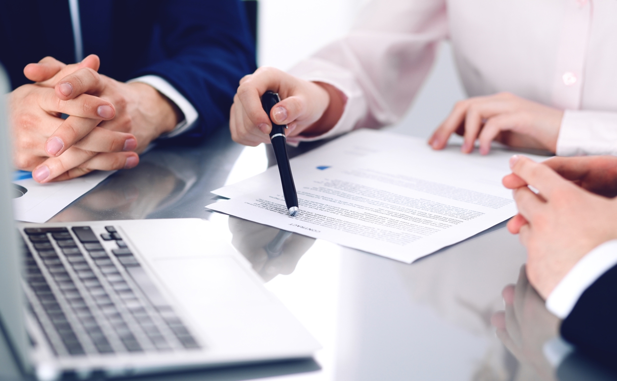 Tre personer i møde omkring kontrakt