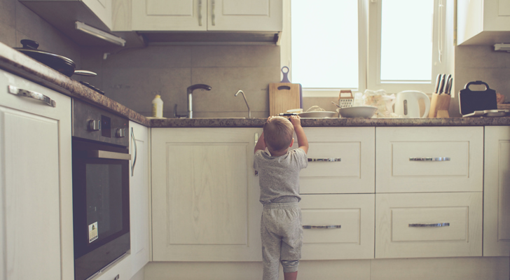 Lille dreng der står i køkken