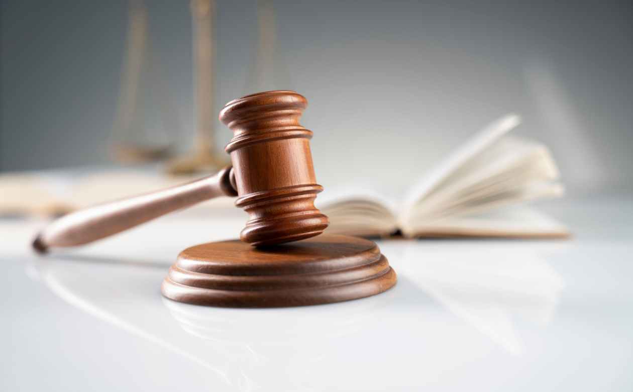 Dommerafgørelse ved dommerhammer med loven i baggrunden 