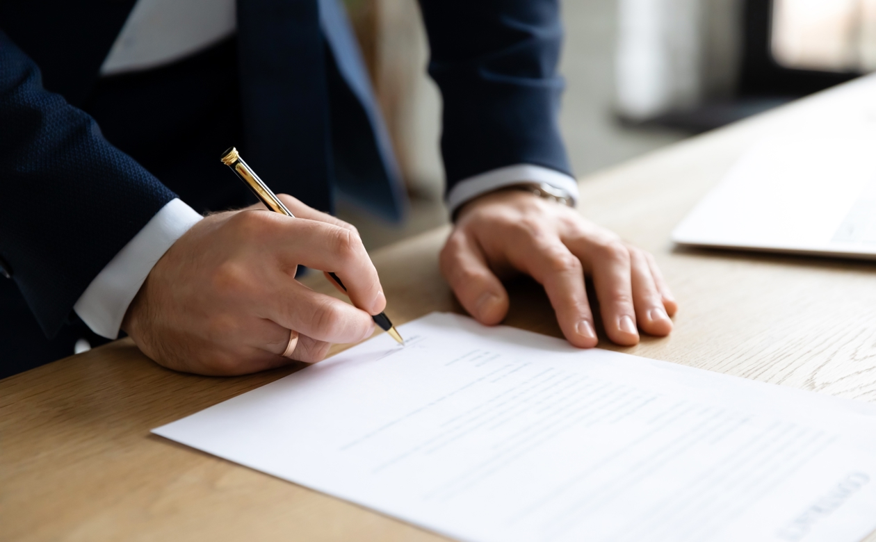 Mand underskriver dokument