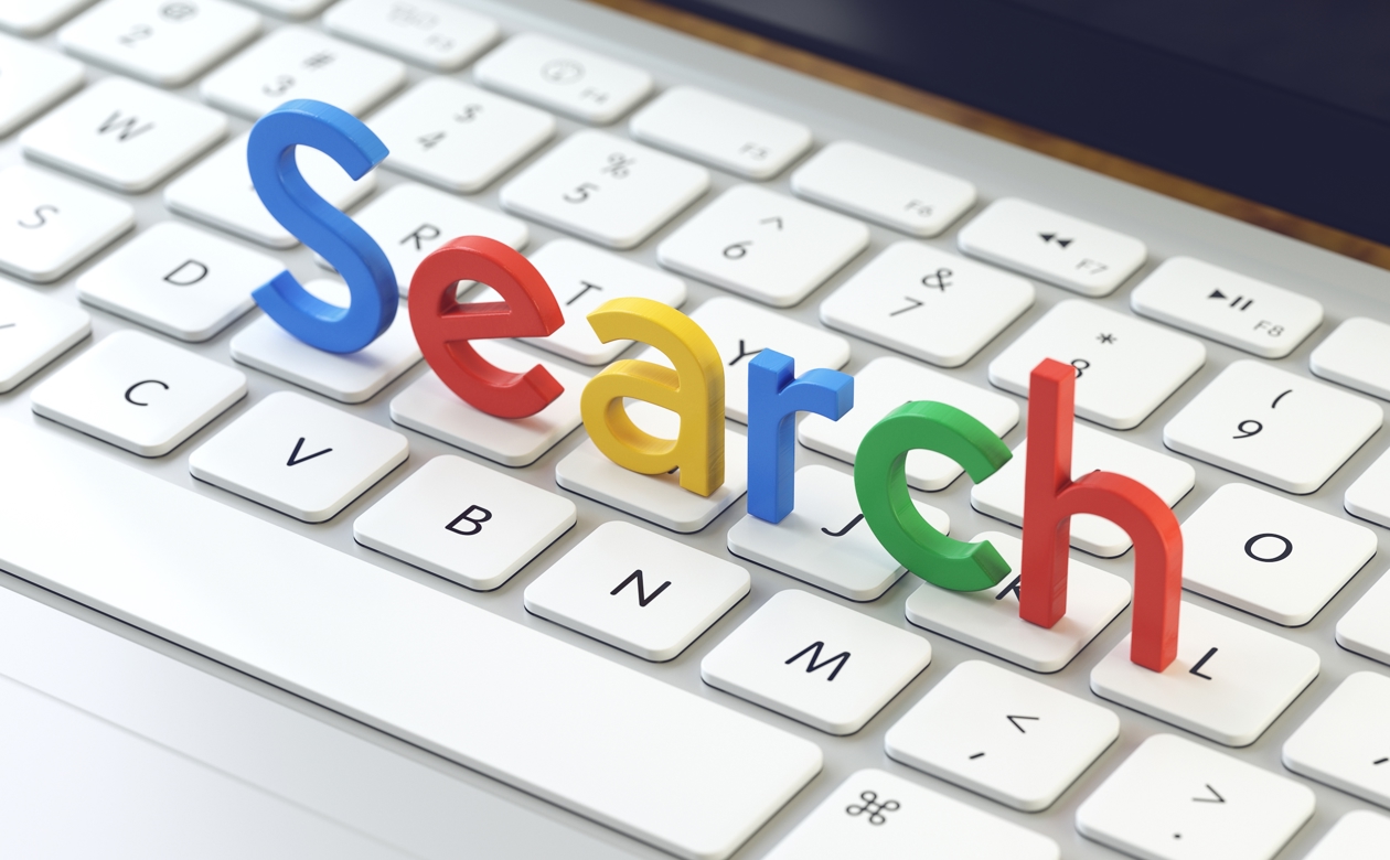 Tastatur med ordet Search ovenpå i Googles farver