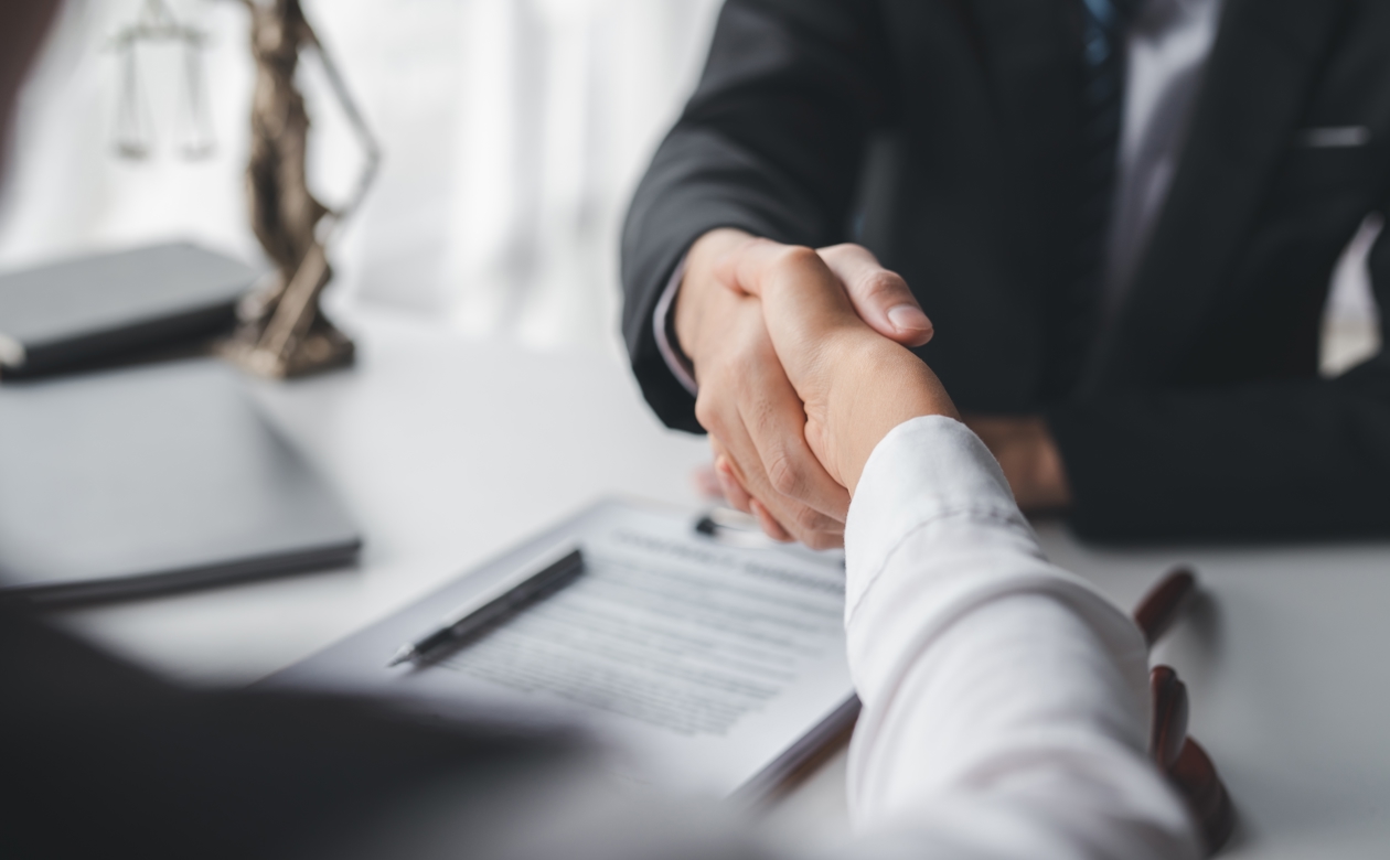 To personer giver hånd over kontrakt