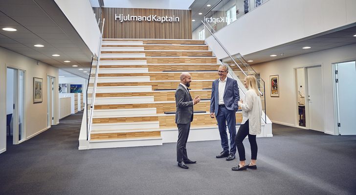 Tre personer snakker ved trappen hos HjulmandKaptain i Aalborg