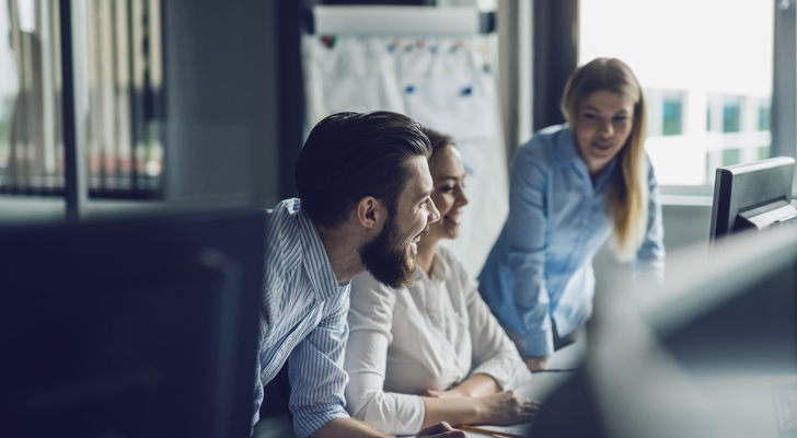 Tre personer arbejder ved computer