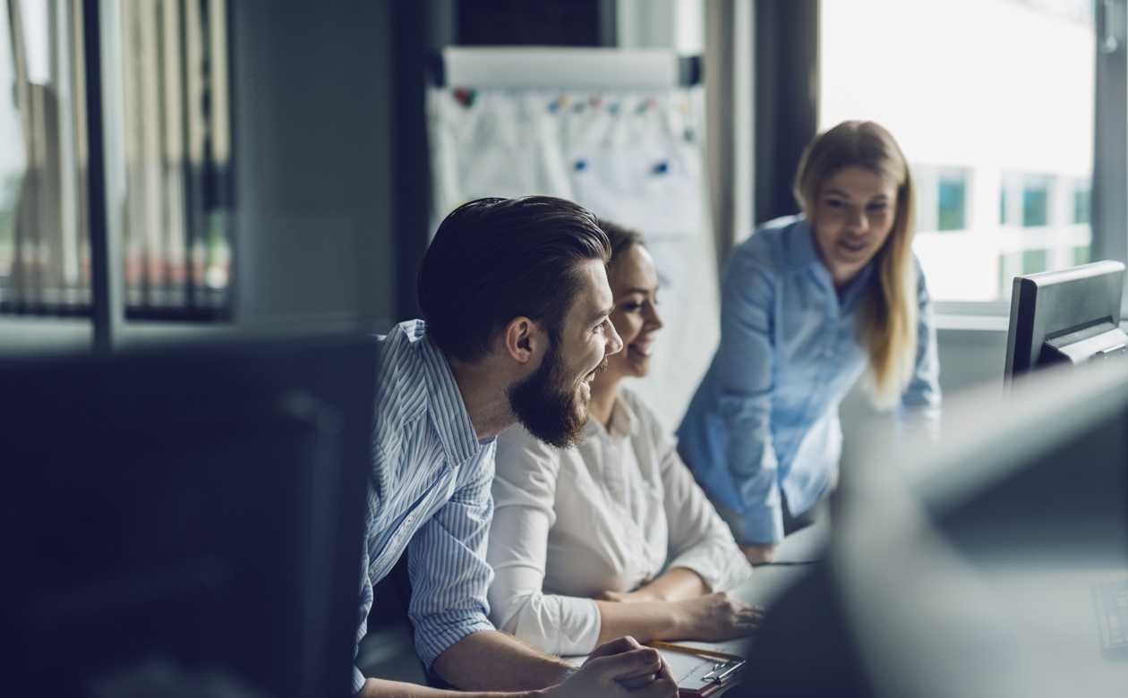 Tre personer arbejder ved computer