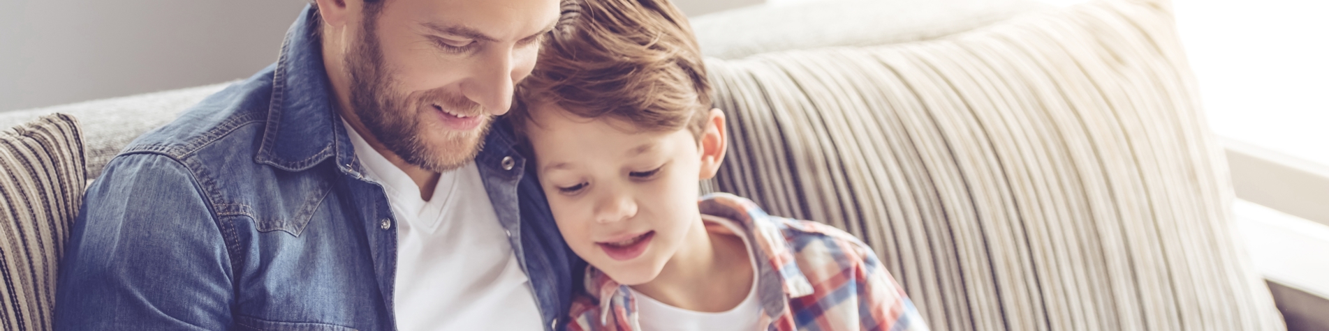 Far og søn læser bog i sofa - børnetestamente