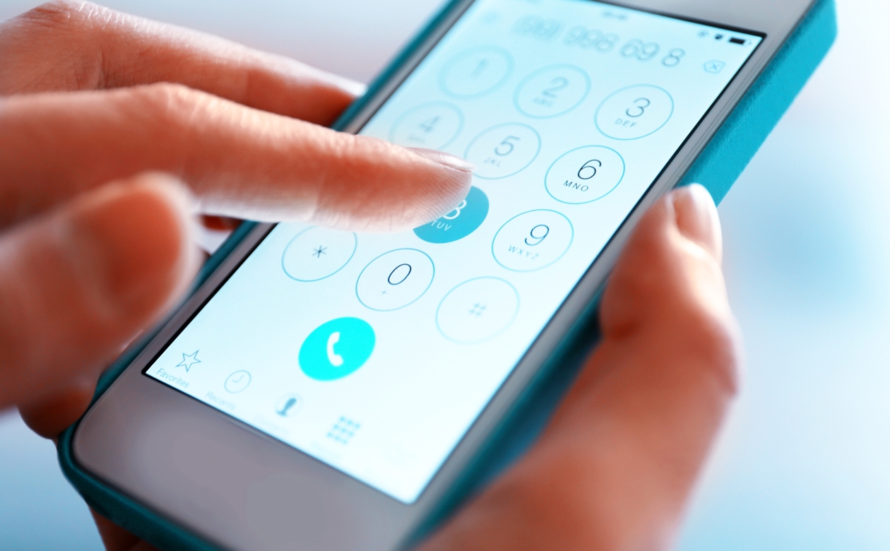 hænder der indtaster telefonnummer på mobil