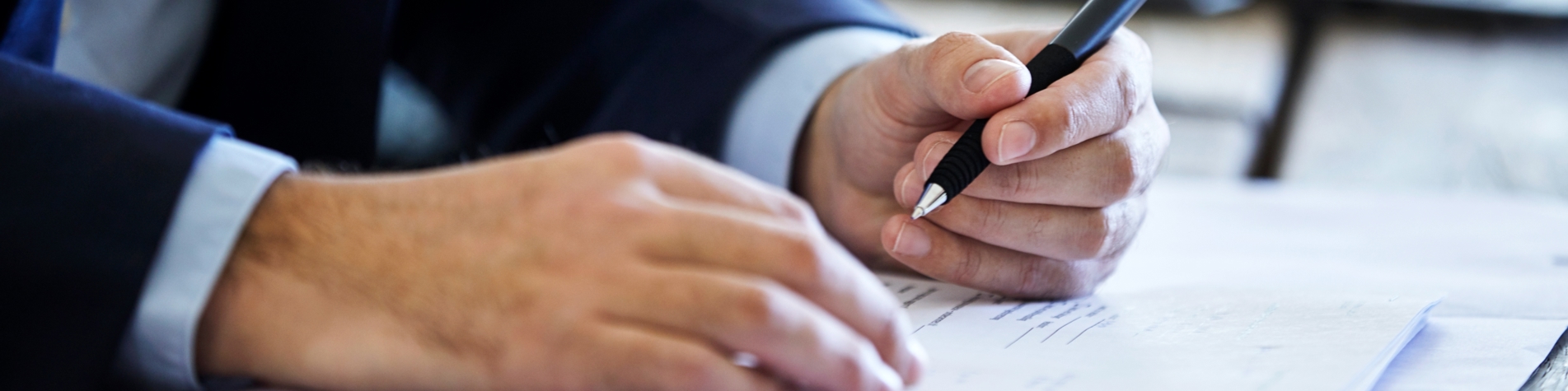 Hænder der underskriver dokument