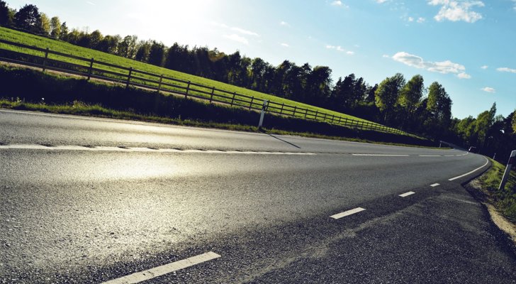 Asfaltvej og mark på den ene side