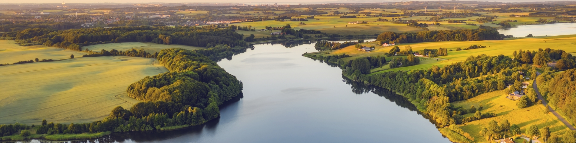 Stor sø med grønne marker på begge sider