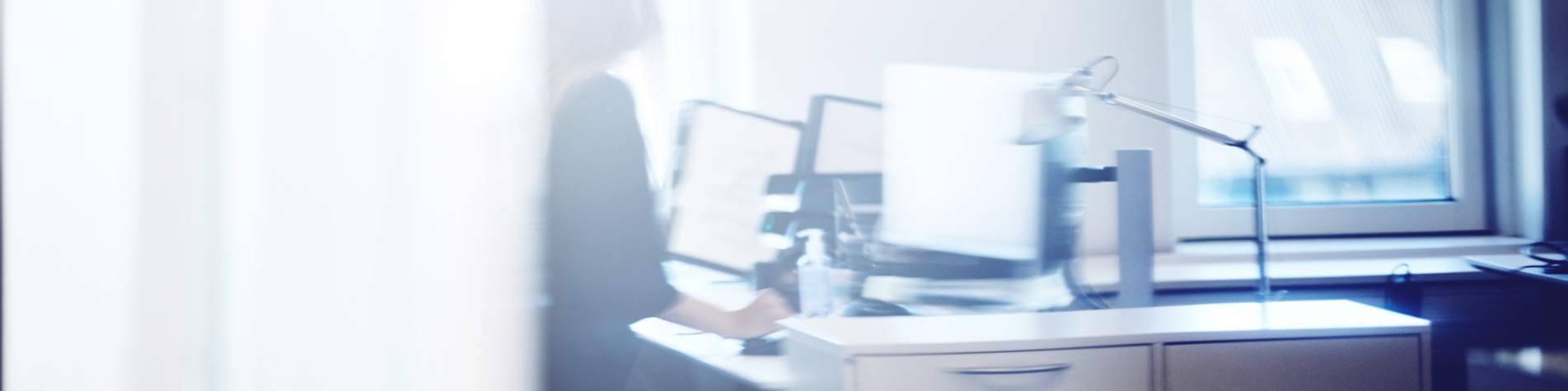Person sidder ved skrivebord foran computer