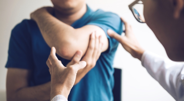 Læge tjekker skulderskade på patient