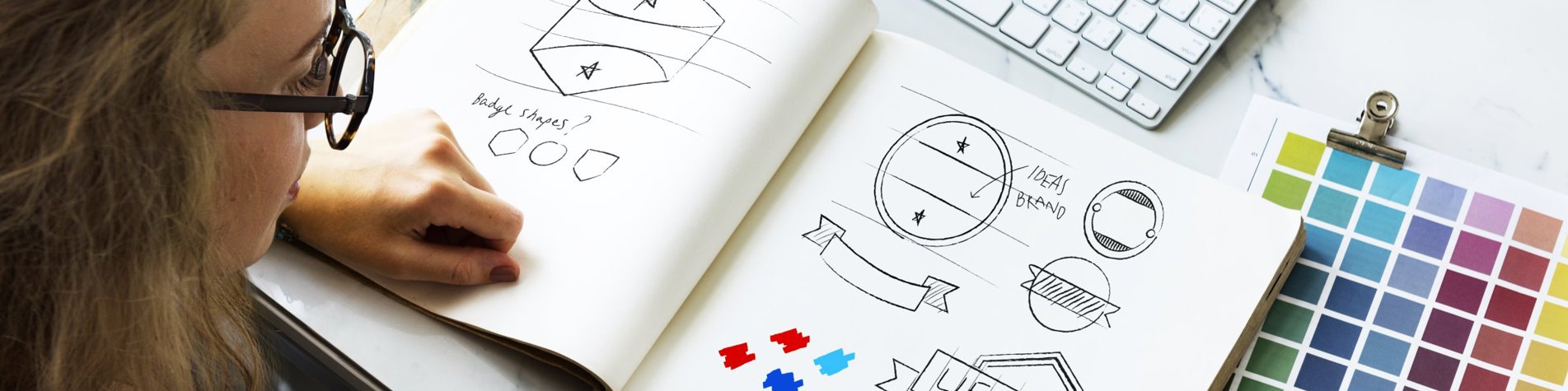 Person sidder med tegneblok og skitserer varemærker - Immaterialret og varemærkeret