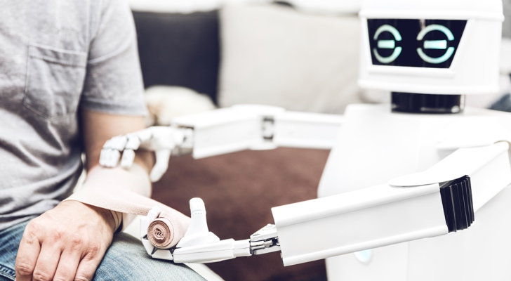 Robot med kunstig intelligens giver person bandage på arm