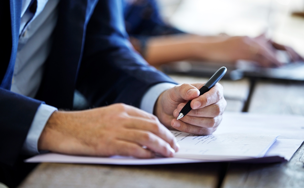 Person underskriver papirdokument