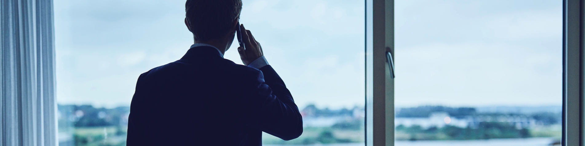 Person taler i telefon og kigger ud af vinduet