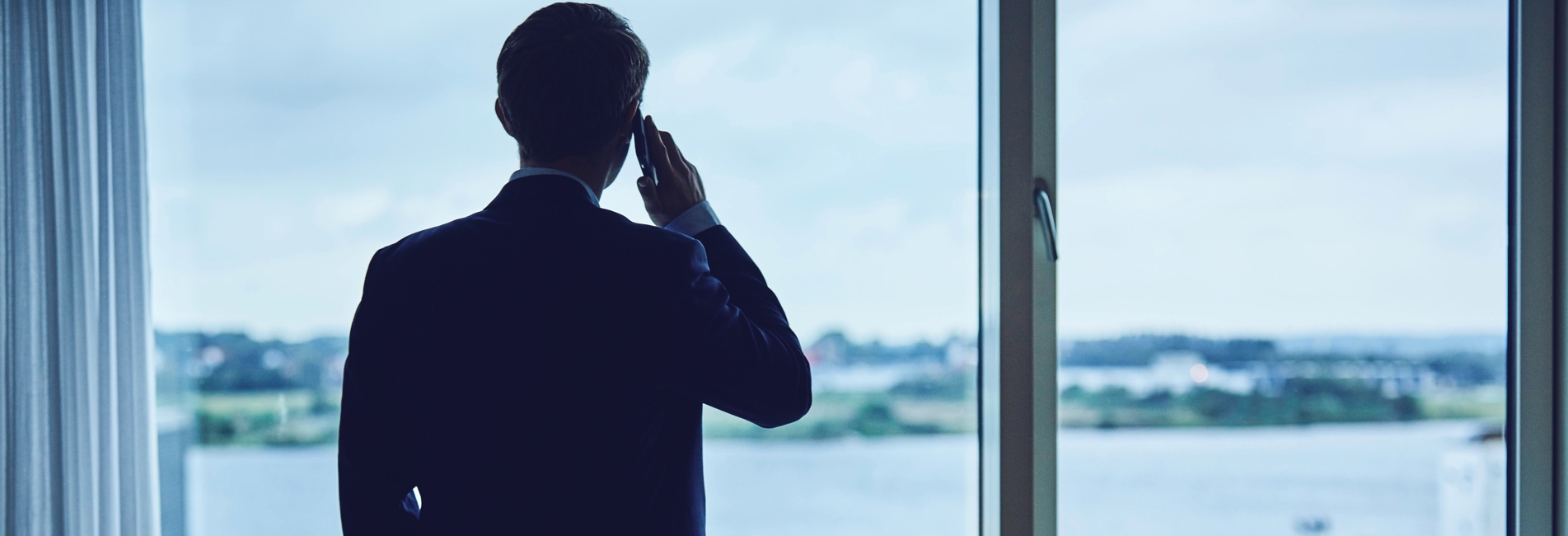 Person taler i telefon og kigger ud af vinduet