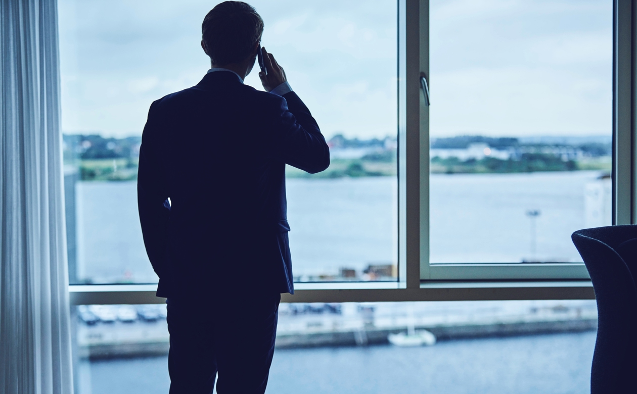 Person taler i telefon og kigger ud af vinduet
