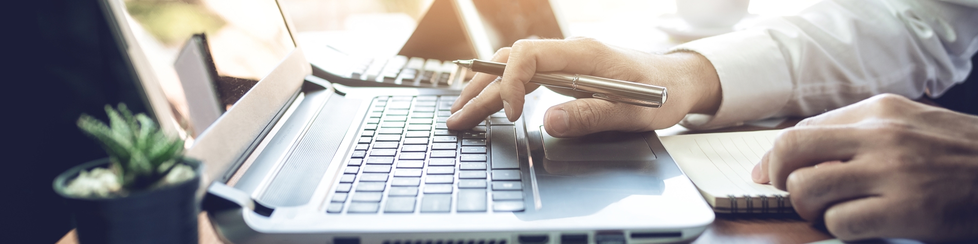 Et closeup af mand som arbejder ved en bærbar