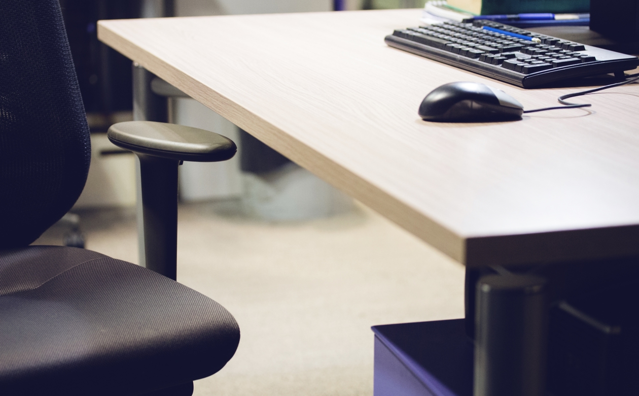 Et tomt skrivebord med kun en computer på