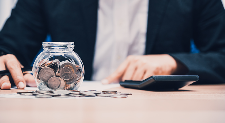 Man tæller penge i glas med lommeregner