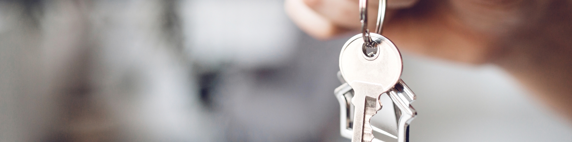 Person som holder husnøgler i hånden