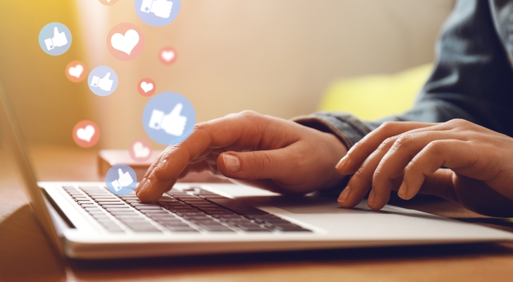 Person sidder ved computer og får likes på sociale medier