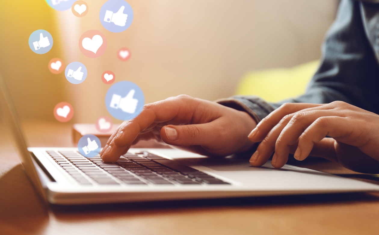 Person sidder ved computer og får likes på sociale medier